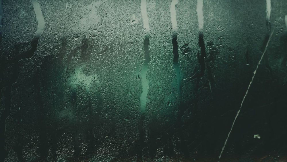 Steam condensation and water streaks on a glass panel