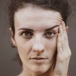 Close-up portrait of a woman with her hand to her face