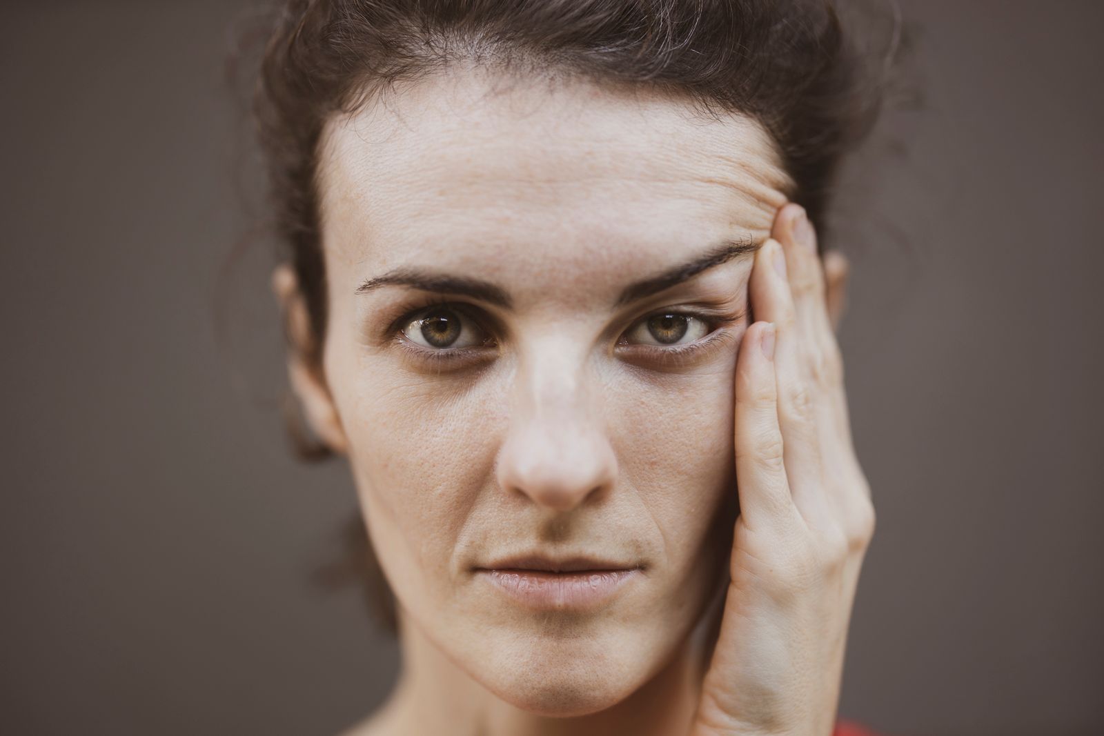 Close-up portrait of a woman with her hand to her face