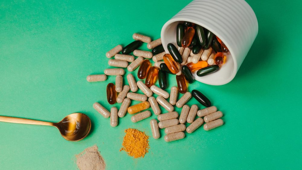 Supplement capsules and powder spilling from a jar