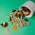 Supplement capsules and powder spilling from a jar