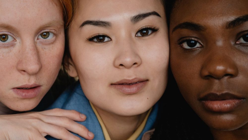 Close-up portrait of three women with different skin tones and types