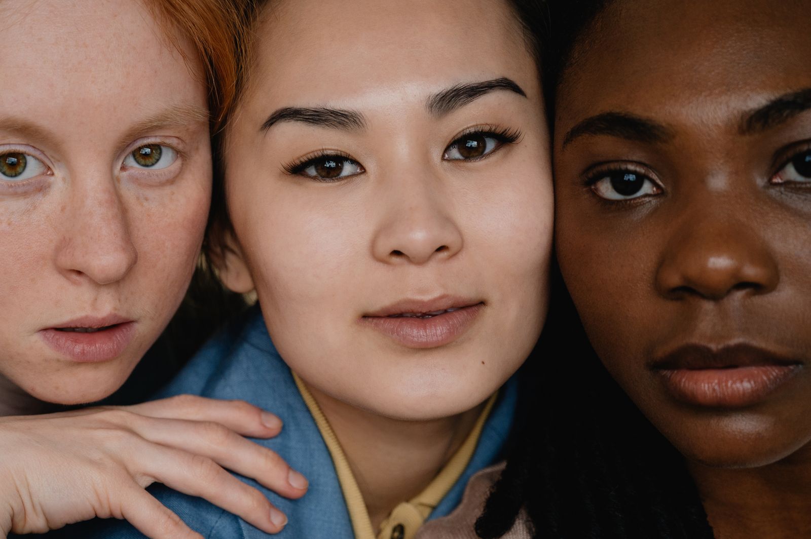 Close-up portrait of three women with different skin tones and types