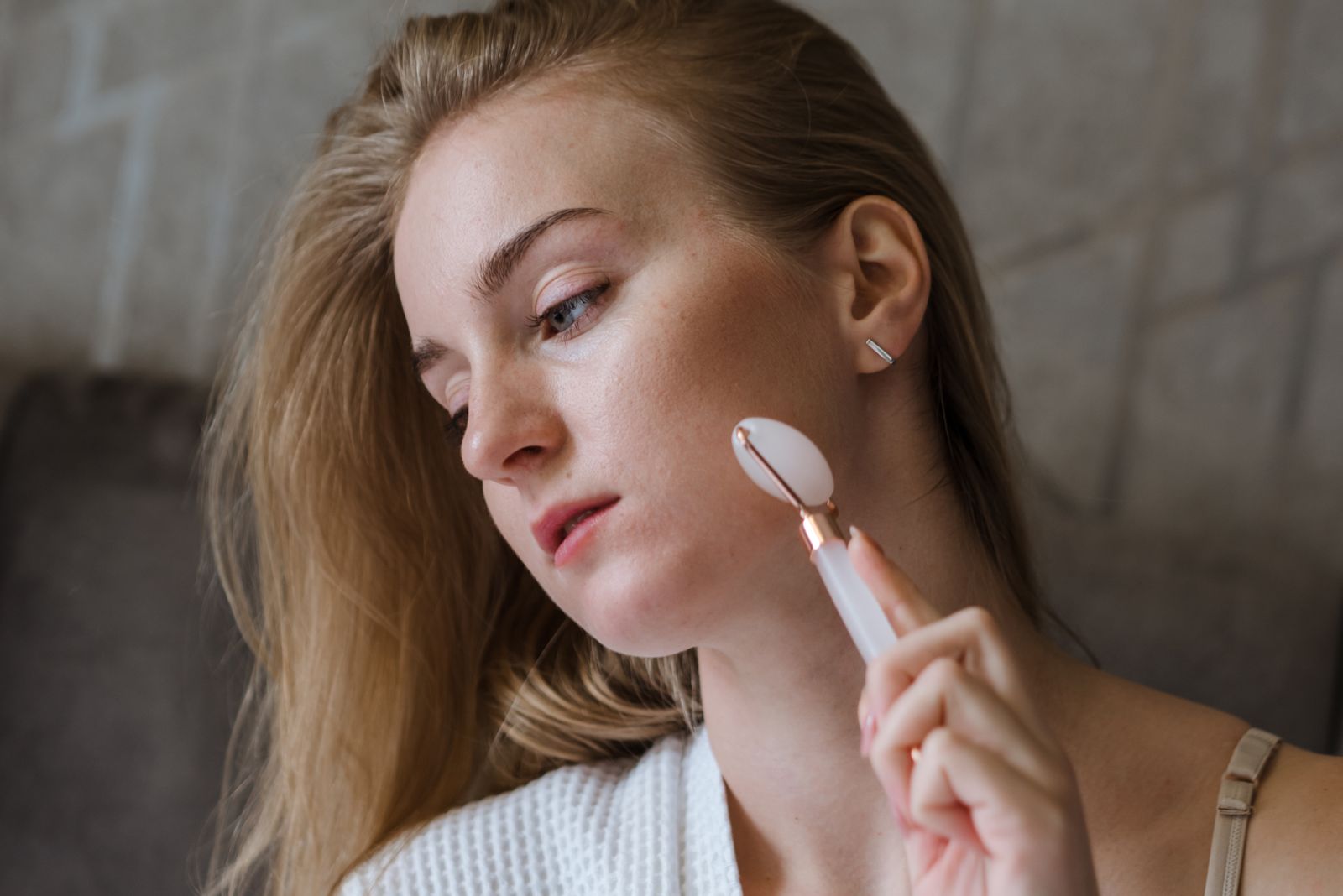 Woman using a facial roller along her cheek