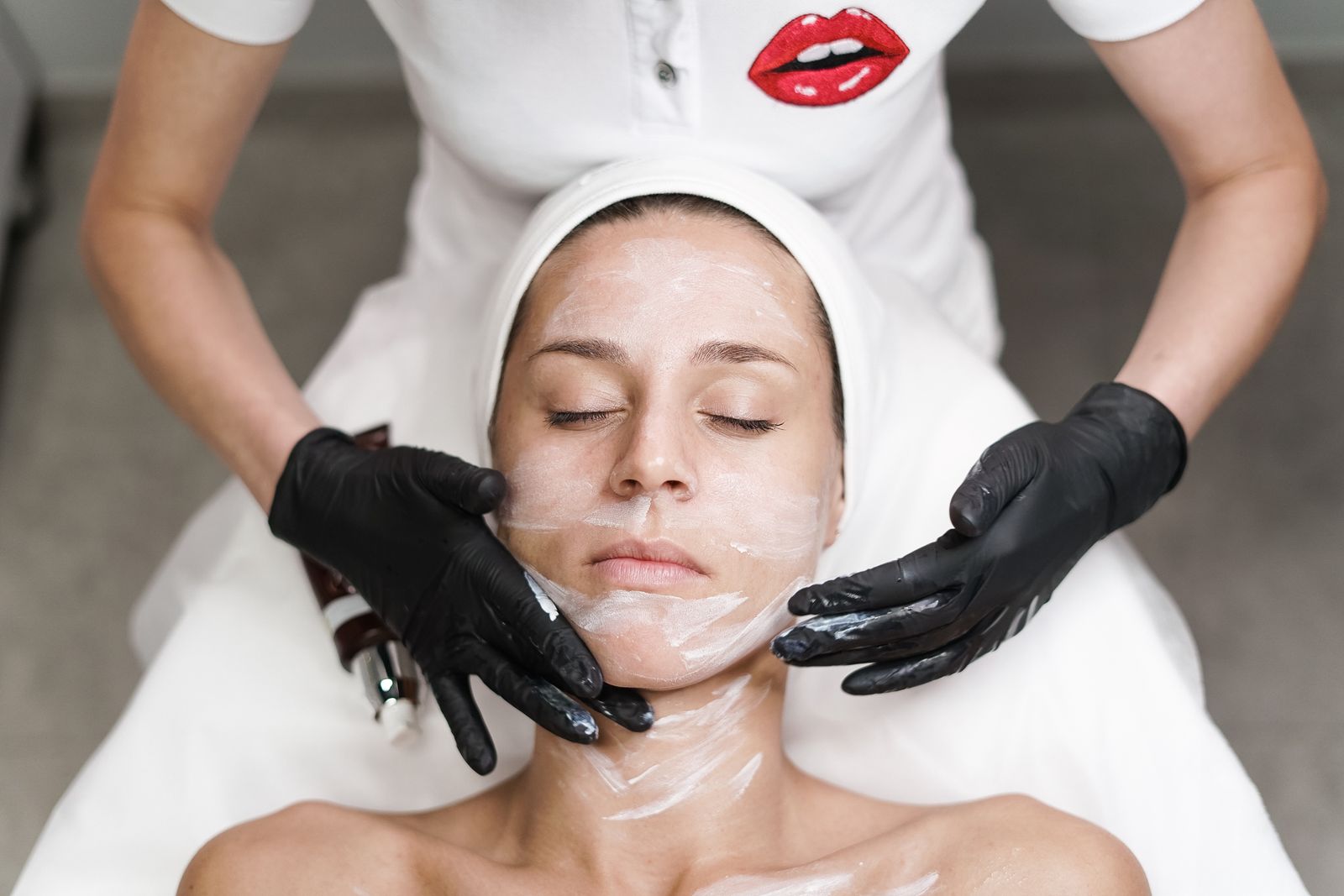 Esthetician performing a facial treatment wearing gloves