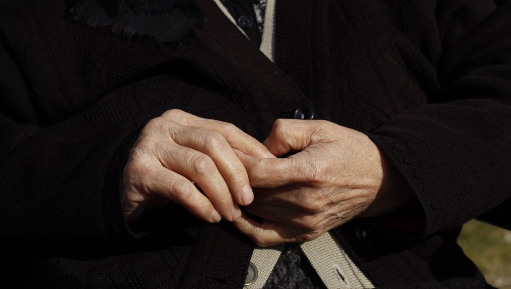 Close-up of an older woman’s clasped hands