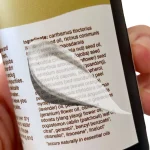 Person reading the ingredient list on a skincare product