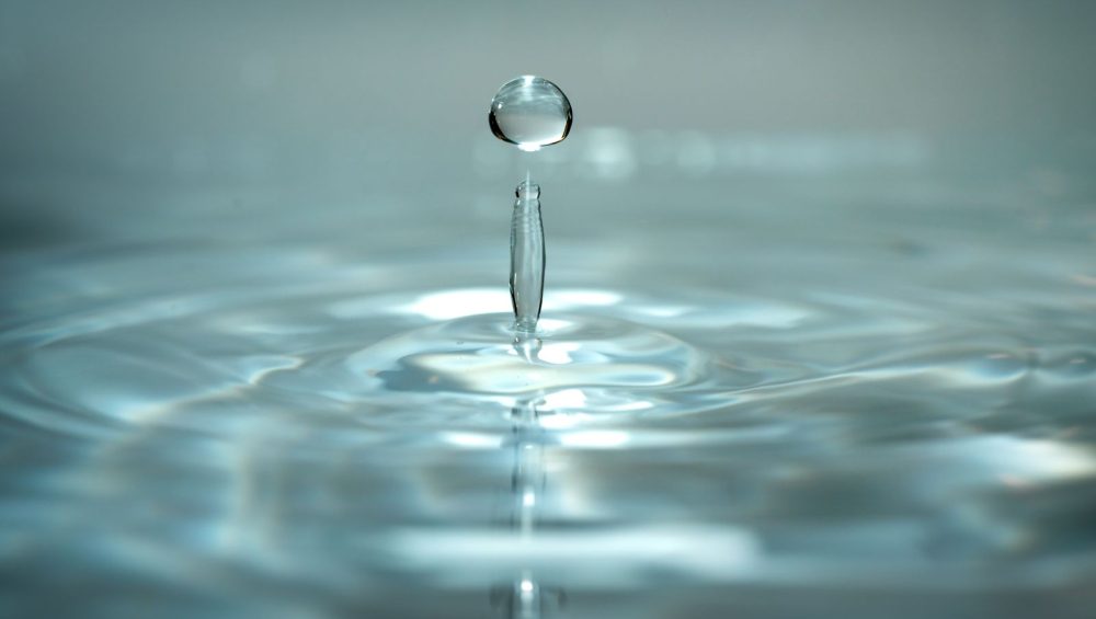 A water droplet falling into water and forming ripples