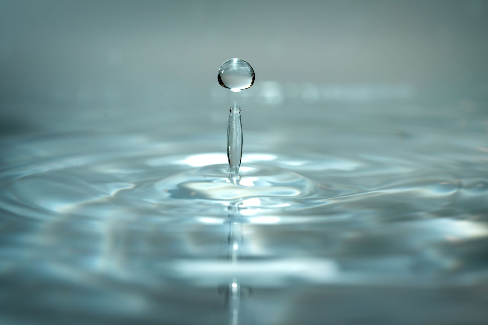 A water droplet falling into water and forming ripples