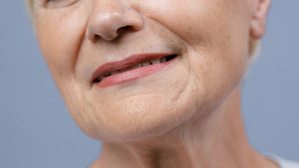 Close-up of a mature woman's lower face and neck showing natural skin texture