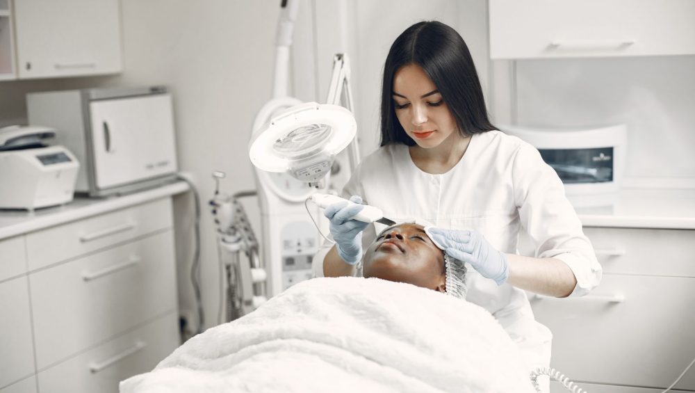Esthetician performing a facial treatment in a treatment room
