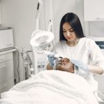 Esthetician performing a facial treatment in a treatment room