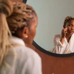 Woman examining her skin in a round mirror