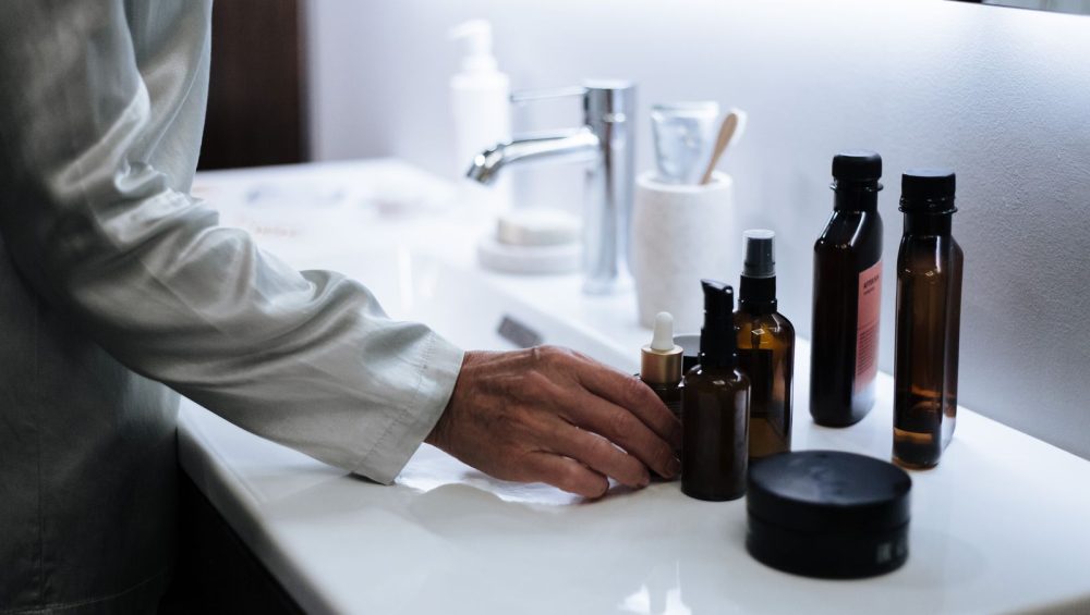 Skincare products stored on a bathroom shelf
