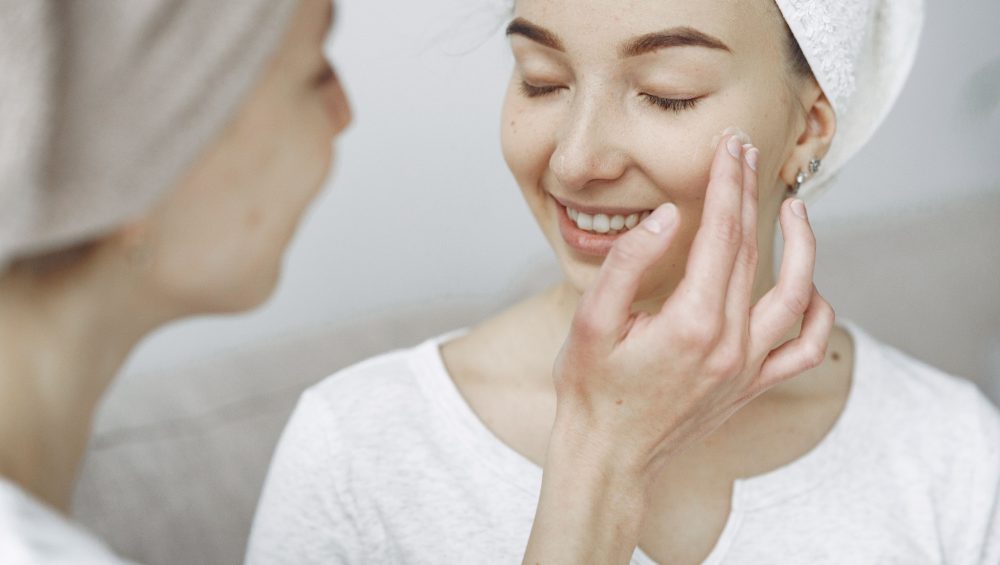 Woman gently applying skincare serum to her face