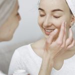 Woman gently applying skincare serum to her face