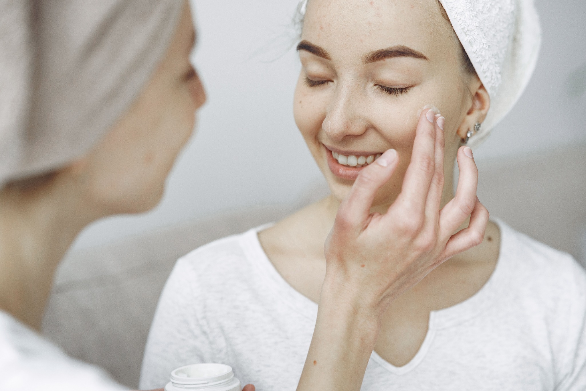 Woman gently applying skincare serum to her face