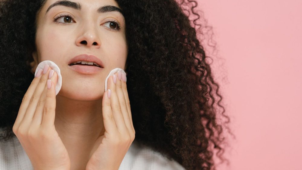Woman using cotton pads on her face