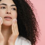 Woman using cotton pads on her face