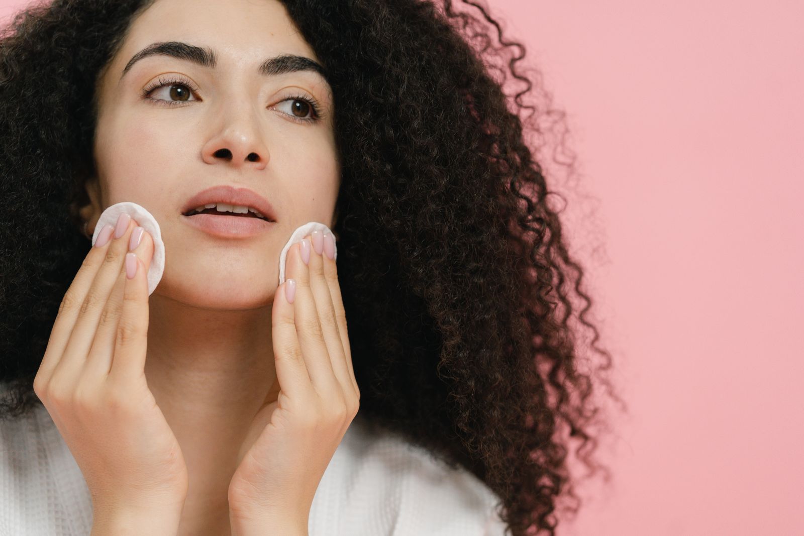 Woman using cotton pads on her face