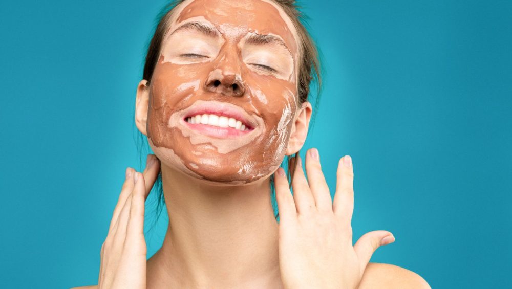 Smiling woman wearing a clay face mask