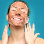 Smiling woman wearing a clay face mask