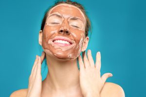 Smiling woman wearing a clay face mask