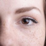Close-up of a woman's eye area without makeup, soft natural light