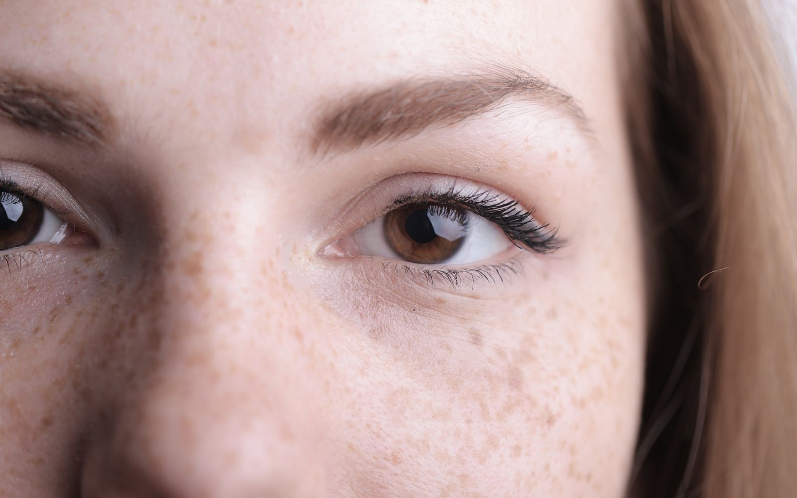 Close-up of a woman's eye area without makeup, soft natural light