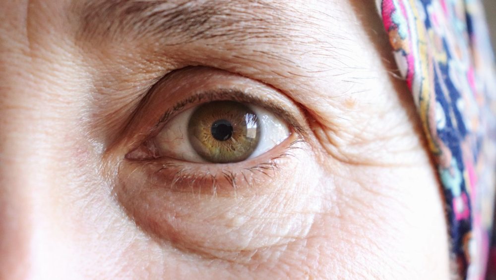 Close-up of a mature woman's eye, fine lines visible at the outer corner, unretouched