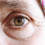 Close-up of a mature woman's eye, fine lines visible at the outer corner, unretouched