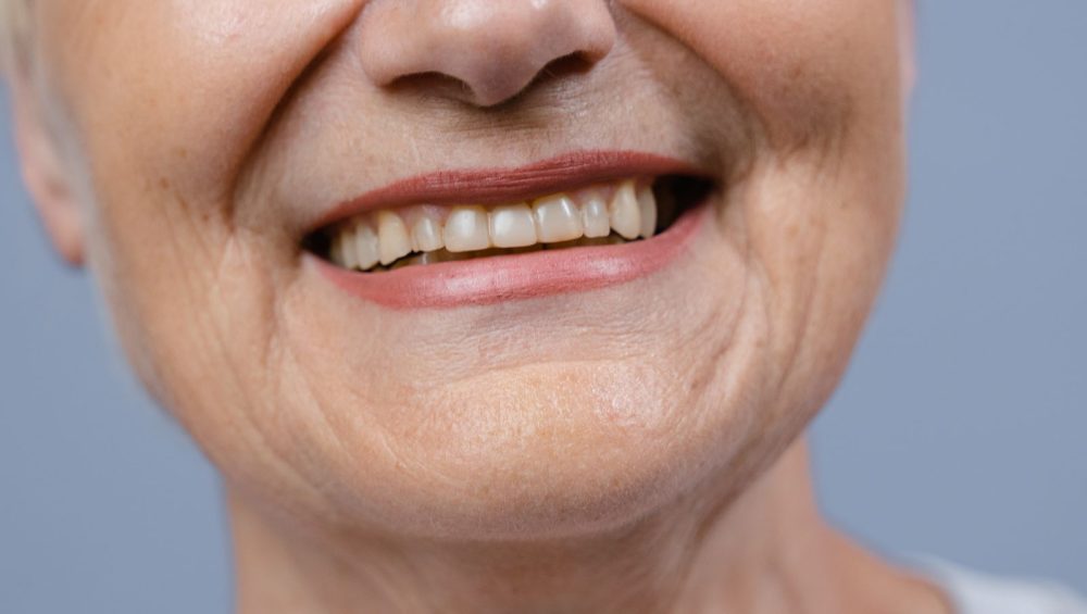 Close-up of a mature woman's smiling mouth and lips, unretouched