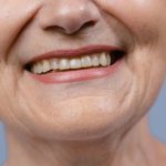 Close-up of a mature woman's smiling mouth and lips, unretouched