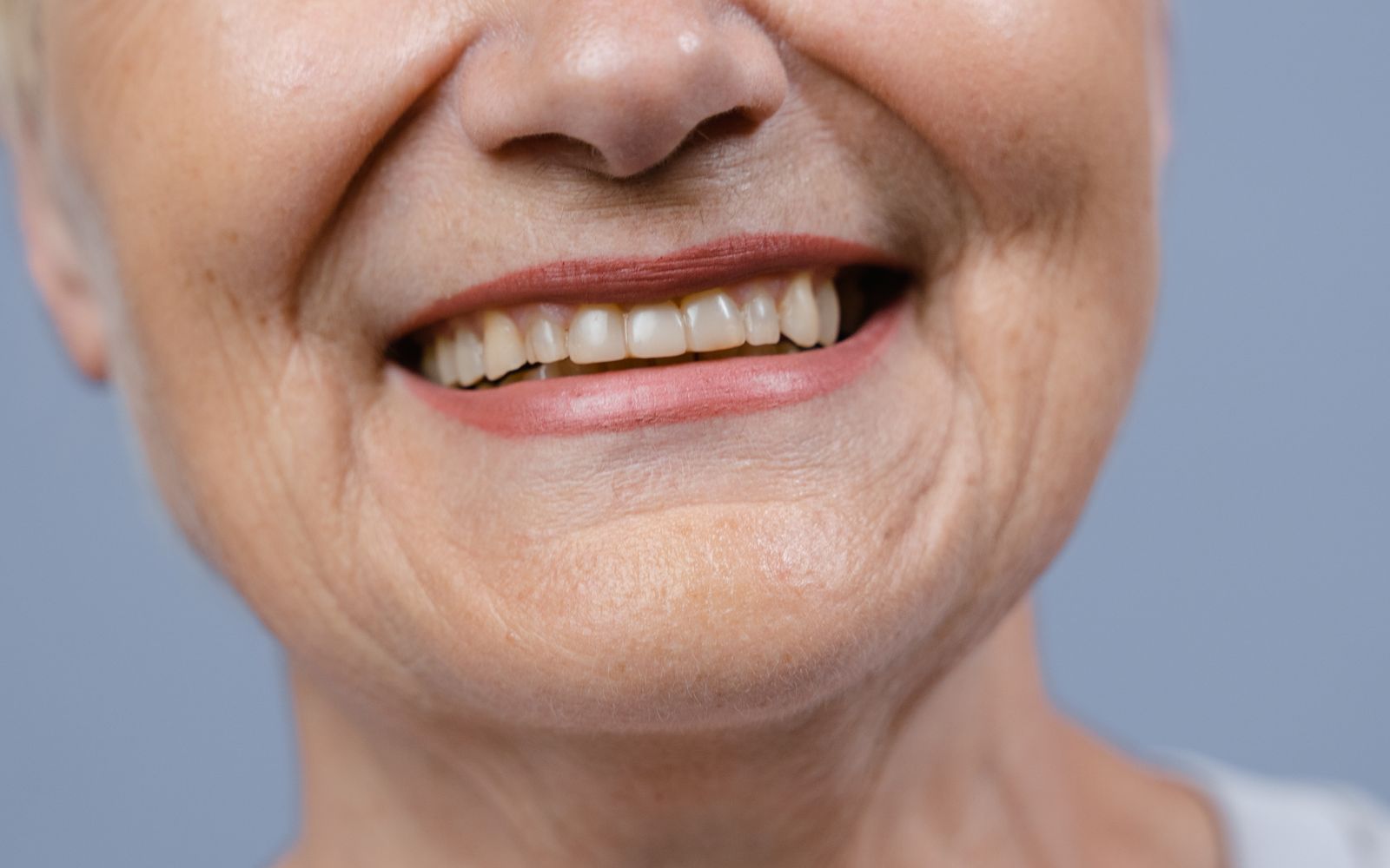 Close-up of a mature woman's smiling mouth and lips, unretouched
