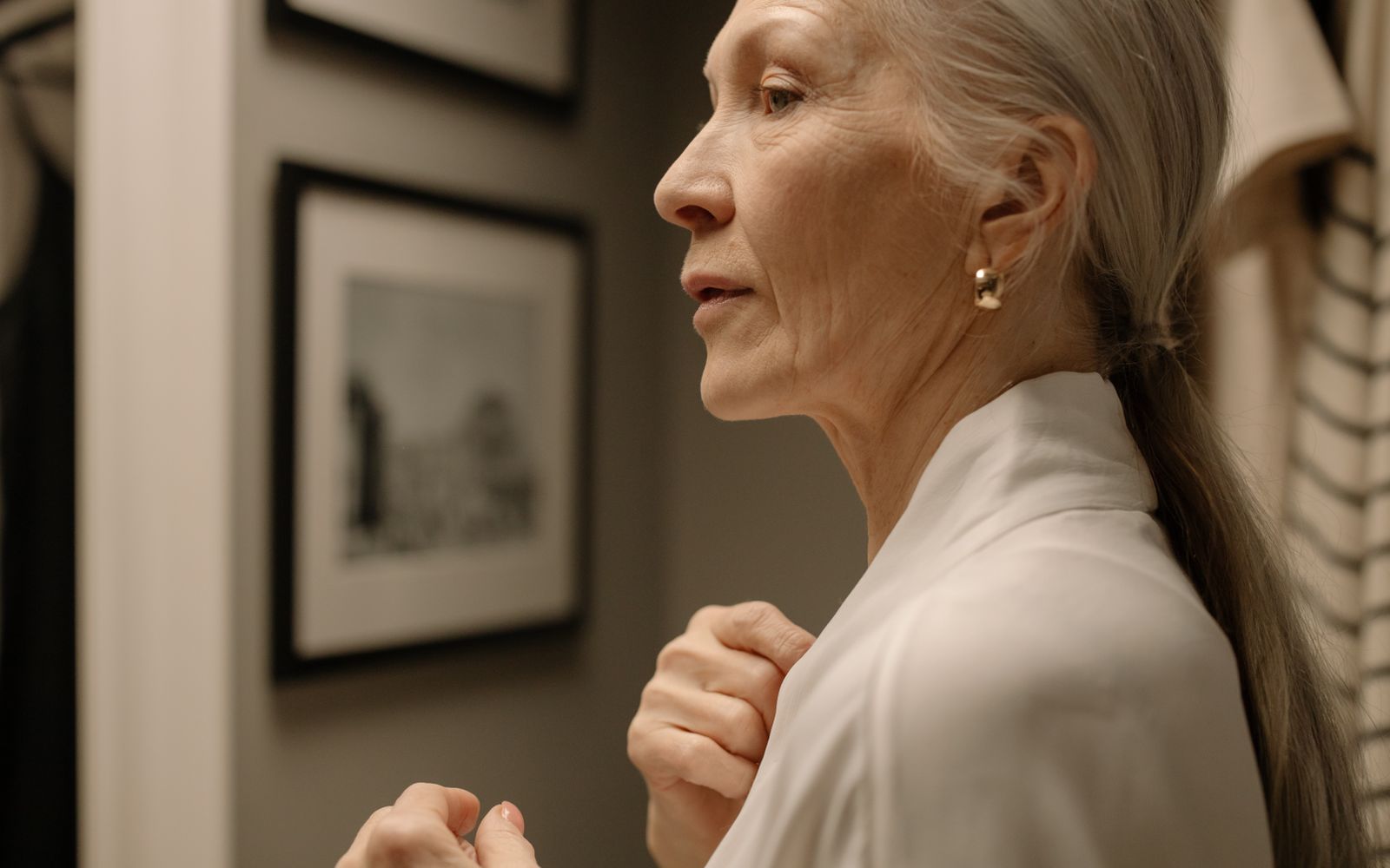 Profile of a woman in her sixties, jaw and neck in soft indoor light, unretouched